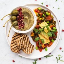 breakfast in vegan box diet - shakshuka with tofu, edamame and kale, baba ghanoush with pomegranate, roll